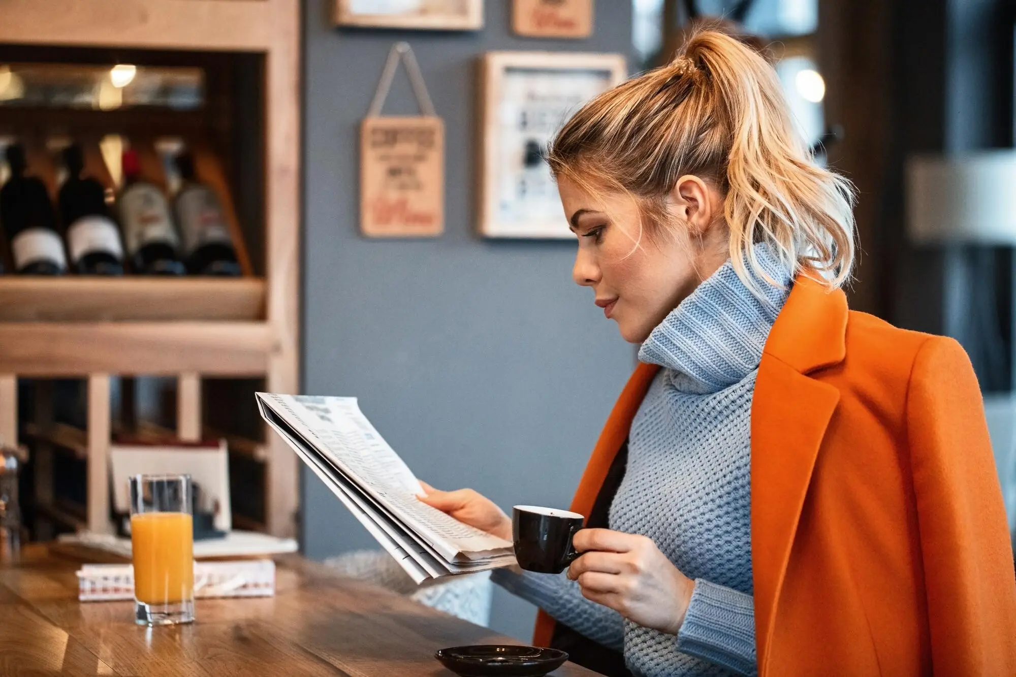 Eine Freiberuflerin entspannt sich während der Kaffeepause und liest in der Cafeteria Zeitung, praxisnah und nachvollziehbar.